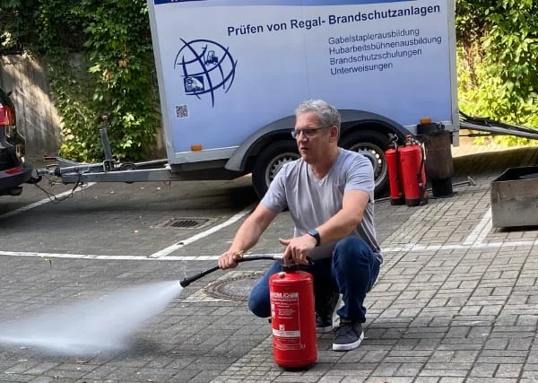 Axel Hahn mit einem Feuerlöscher im Rahmen einer Schulung